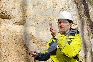 Geologist examines a sample of stone outdoor