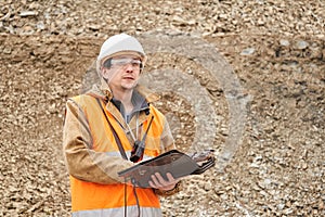 Geologist or mining engineer with bag tablet for working documentation at the mining site