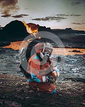 Geologist in a protective suit examines the soil near the volcano