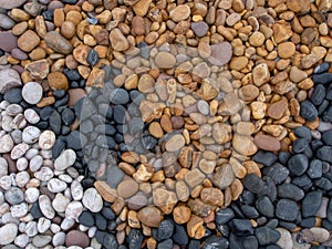 Geology. Sea pebbles on beach, various colors and types of stone. Multicoloured stones - black, white, yellow.