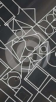 Geometric abstract composition featuring interlocking white lines on a dark surface.