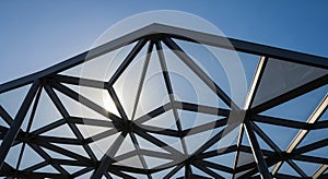 A geometric architectural structure with a metal framework forms triangular patterns,