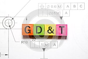 Geometric dimensioning and tolerancing conceptual text on colorful blocks on a engineering part drawing