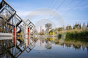 Geometric Metal Frames and Red Panels Reflected in Still Water