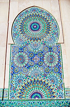 Geometric muslim mosaic in Islamic mosque, beautiful Arabic tile pattern and mosaic on the wall and doors of mosque in Casablanca