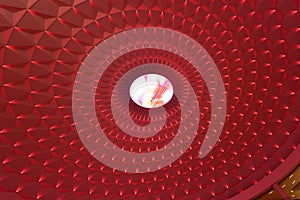Geometric pattern on circular top of modern building lit by red led lights,landscape lighting