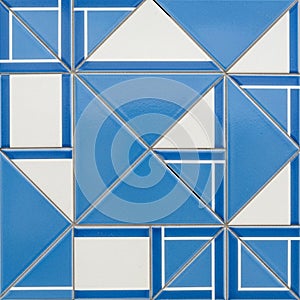 Geometric pattern featuring blue and white tiles arranged in a symmetrical design. Each tile