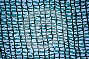 Geometric pattern of plastic mesh on sky background