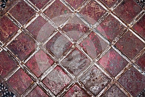 Geometric pattern of tin strips nailed to rusty and threadbare sheet metal, painted once in red.