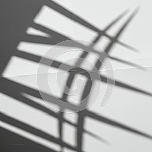 Geometric shadows are cast on a white textured surface, creating a pattern of