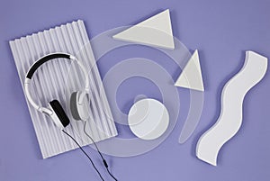 Geometric shapes for product presentation with headphones on a violet background. Top view, flat lay. Music, still life.