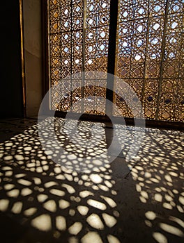 Geometric Sunlight Patterns Through Ornate Window
