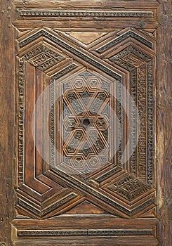 Geometrical and floral engraved patterns of Mamluk style wooden ornate door leaf photo