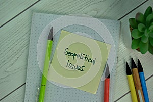 Geopolitical Issues write on sticky notes isolated on Wooden Table