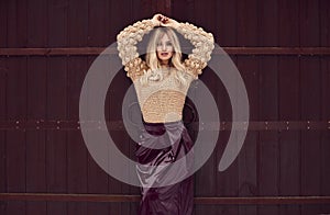 Georgeous elegant blonde in bright dress on wooden background