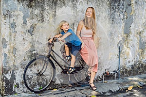 Georgetown, Penang, Malaysia - April 20, 2018: Mother and son on a bicycle. Public street art Name Children on a bicycle