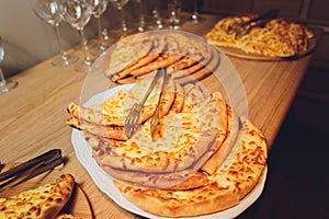 Georgian cuisine slised megrelian khachapuri bread on the wooden table.