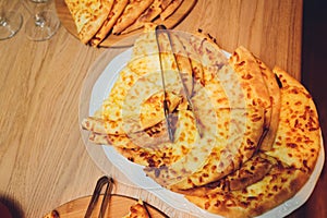 Georgian cuisine slised megrelian khachapuri bread on the wooden table.