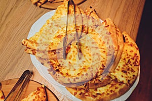 Georgian cuisine slised megrelian khachapuri bread on the wooden table.