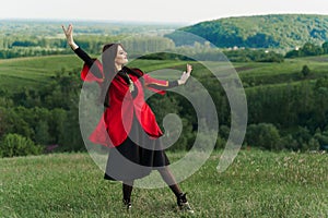 Georgian girl dances national dance named: rachuli, acharuli, osuri, shalaxo, mtiuluri. on the green hills of Georgia photo