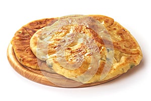Georgian khachapuri with cheese and green herbs inside, isolated on white background