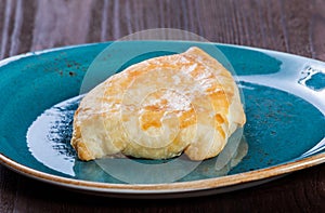 Georgian khachapuri flatbread or flat cake with cheese on a plate Homemade baking. Top view.