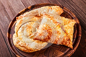 Georgian khachapuri - flatbreads with cheese on wooden cutting board.