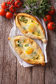 Georgian khachapuri and fresh vegetables vertical top view