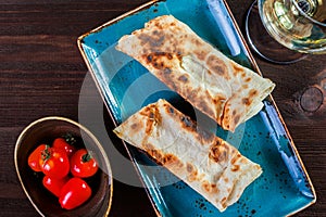 Georgian lavash, fresh pita bread on a plate on wooden background. Caucasian kitchen.