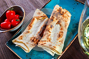 Georgian lavash, fresh pita bread on a plate on wooden background. Caucasian kitchen.