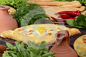 Georgian traditional cuisine. Ajarian traditional flatbread khachapuri. Open pie with mozzarella cheese and egg