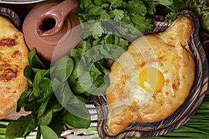 Georgian traditional cuisine. Ajarian traditional flatbread khachapuri. Open pie with mozzarella cheese and egg