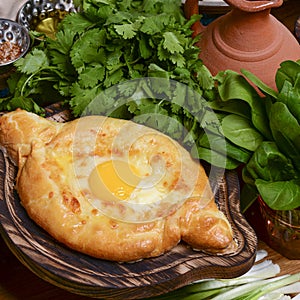 Georgian traditional cuisine. Ajarian traditional flatbread khachapuri. Open pie with mozzarella cheese and egg
