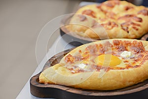 Georgian traditional cuisine. Ajarian traditional flatbread khachapuri. Open pie with mozzarella cheese and egg