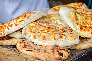 Georgian traditional dish khachapuri, pastry flat cake cheese-filled bread fried on the grill, BBQ. Fresh hot tasty street food in