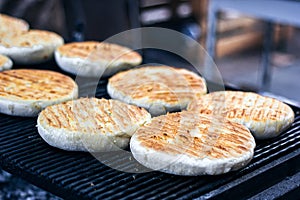 Georgian traditional dish khachapuri, pastry flat cake cheese-filled bread fried on the grill, BBQ. Fresh hot tasty street food in