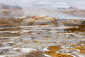 Geothermal field Namaskard, Iceland. Desolate landscape with mud volcano and hot steam.