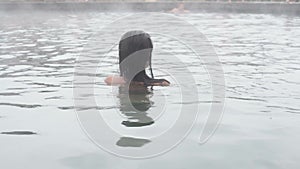 Geothermal spa. Woman relaxing in hot spring pool. Girl enjoying bathing opendoor basin with in warm mineral water 25fps