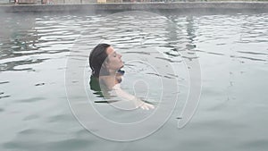 Geothermal spa. Woman relaxing in hot spring pool. Girl enjoying bathing opendoor basin with in warm mineral water 25fps
