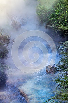 Geothermal steam rising above a heated running river.