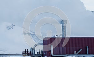 Geothermic plant with clear white smoke and pipes photo