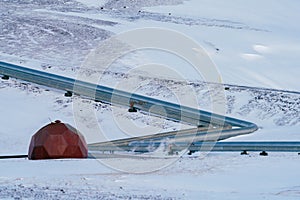 Geothermic plant well and pipes over snow covered landscape photo