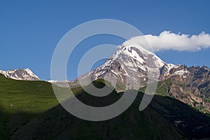 Gergeti trinity church or Tsminda Sameba with background of mountains landscape, Stepantsminda, Kazbegi city, Georgia