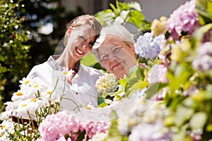 Geriatric nurse with elderly woman in the garden photo