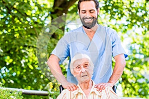 Geriatric nurse giving senior woman massage photo