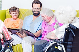 Geriatric nurse looking at pictures with seniors