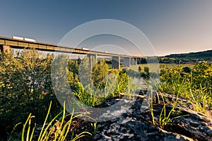 German Autobahn bridge for the highway A3 over the danube river near Regensburg with moving cars in golden afternoon light on