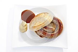 German Bratwurst, fried sausage and bread roll on plate