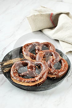 German Brezel Pretzel with Sesame Seed on Rustic Plate