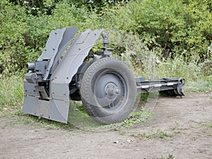 German cannon during the second world war on a cloudy summer day painted in black camouflage.